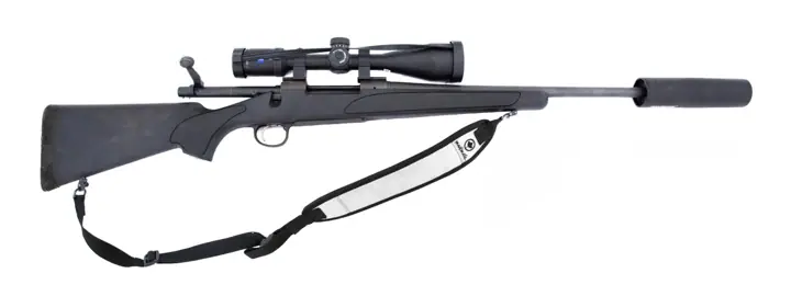A black bolt-action hunting rifle with a telescopic sight, suppressor and sling, on a white background